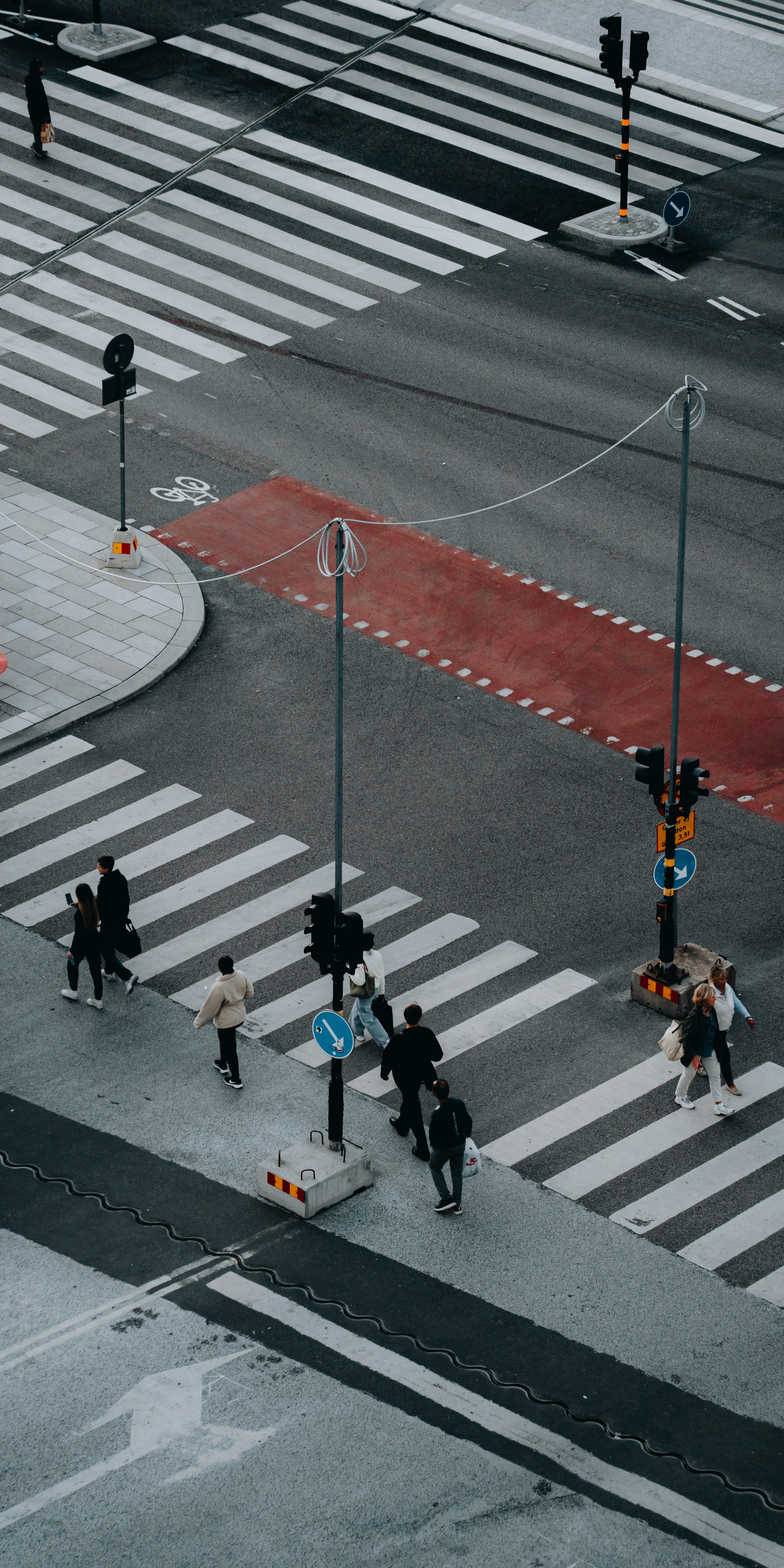 Övergångställe i stockholm där männsikor går över fotat från ett fågelperspektiv 